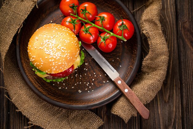 テーブルの上にトマトと食欲をそそるハンバーガー