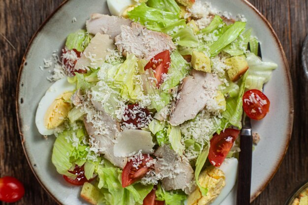 Appetizing caesar salad in a plate on a wooden table