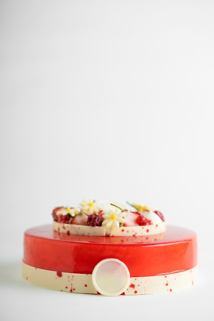 An appetizing cake displayed on a red and white striped cake stand ready to be eaten