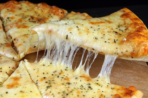 食欲をそそるチーズピザ、細かく切る