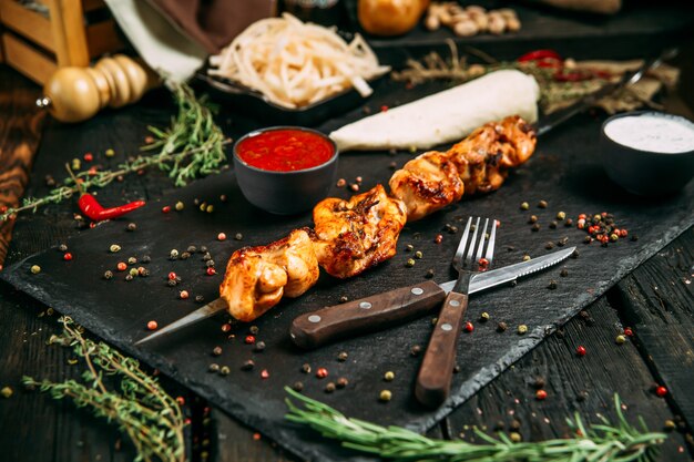 Appetizing chicken kebab on a dark wooden surface