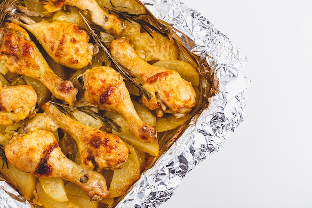 Appetizing Chicken Legs Baked with Potatoes and Rosemary in Foil.