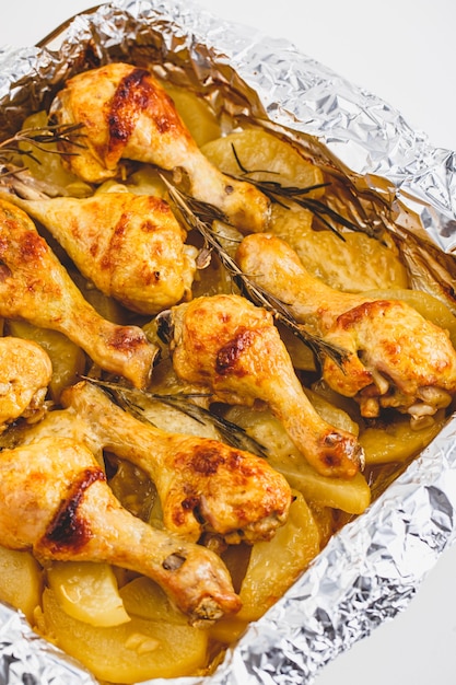 Appetizing Chicken Legs Baked with Potatoes and Rosemary in Foil.