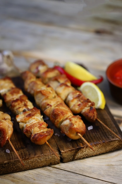 Appetizing chicken skewers on wooden sticks.