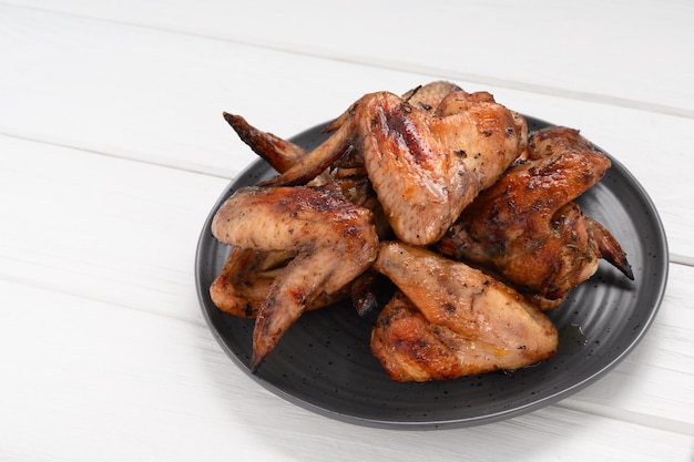 Appetizing chicken wings grilled barbecue with spices and vegetables until crisp