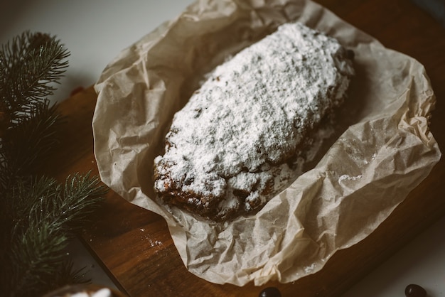 크리스마스 장식이 있는 나무 판자에 있는 식욕을 돋우는 크리스마스 파이 stollen