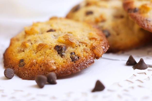 Аппетитное печенье с орехами и шоколадными каплями на белом фоне крупным планом