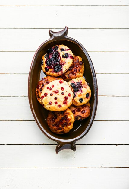 Appetizing cottage cheese pancakes or syrniki with summer berries. Curd pancakes with red and black currants