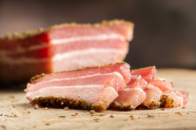 まな板のハーブのスパイスで食欲をそそる硬化豚バラ肉