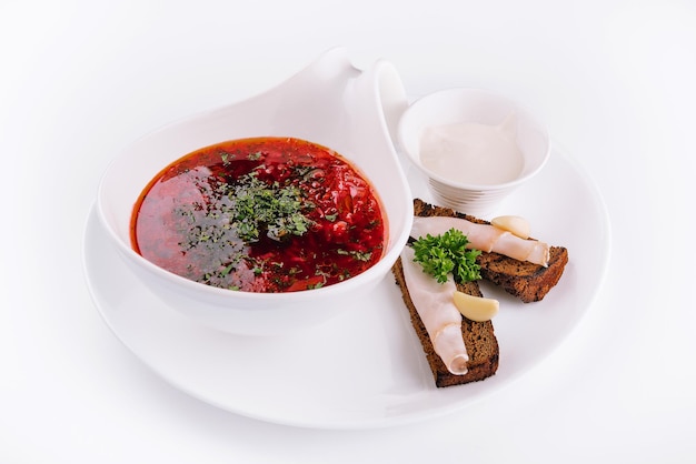 Appetizing dish borscht served with bread lard slicrs and sour cream