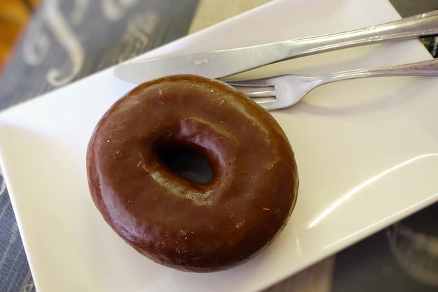 Appetizing donut with chocolate icing on a plate