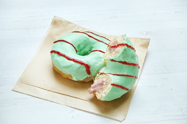 녹색 장식 및 나무 테이블에 공예 종이에 나무 딸기 충전 식욕을 돋 우는 도넛. 도넛을 자릅니다. 클래식 아메리칸 디저트 과자