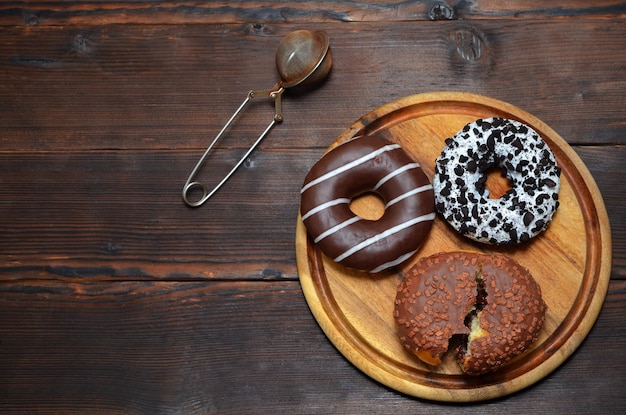 Appetizing donuts in glaze on a wooden background flat lay copy space