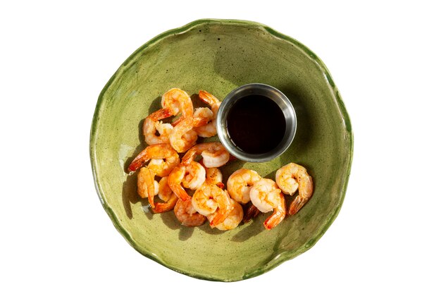 Appetizing fried shrimp with soy sauce in a green plate