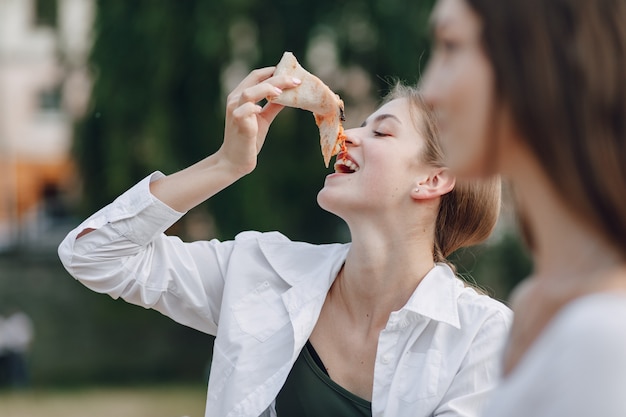 Appetizing girl eating pizza