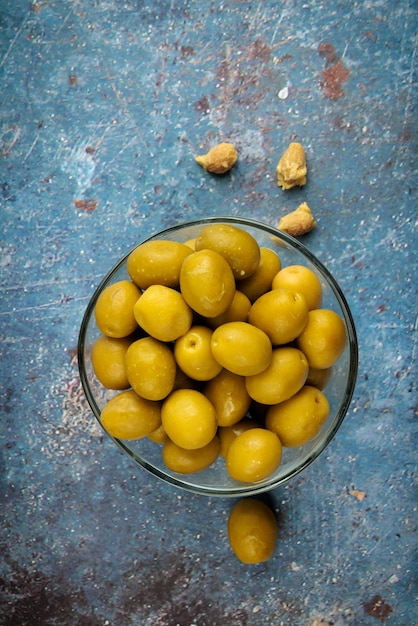 Appetizing green olives  on rustic background.