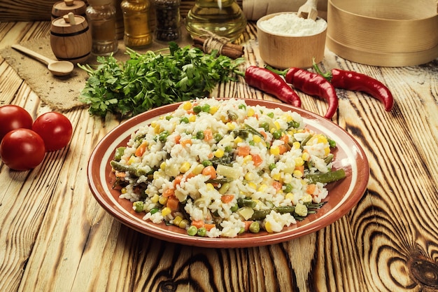 Appetizing healthy Bowl of pasta orzo or rice risotto with vegetables on a wooden background