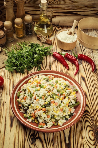 Appetizing healthy Bowl of pasta orzo or rice risotto with vegetables on a wooden background