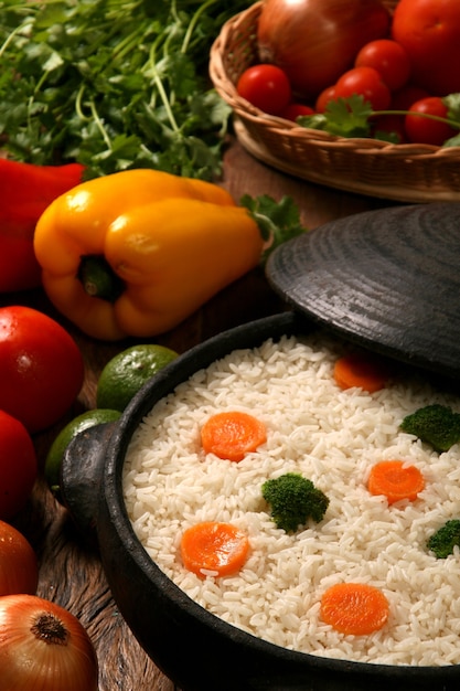 Appetizing healthy rice with vegetables in white plate on a wooden table. rice colored