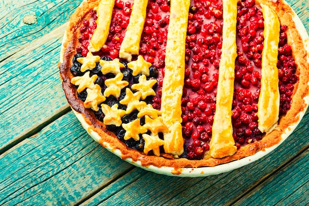 Photo appetizing homemade pie with red and black currants. sweet dessert. american flag.usa berry pie.