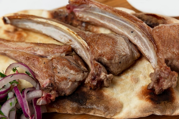 Costolette di agnello appetitose su pane pita piatto tradizionale della cucina caucasica primo piano