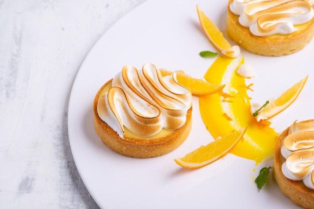 Appetizing lemon tartlets with meringue served on a white plate