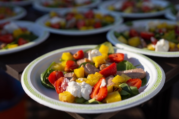 appetizing light salads with strawberries in plates on the table