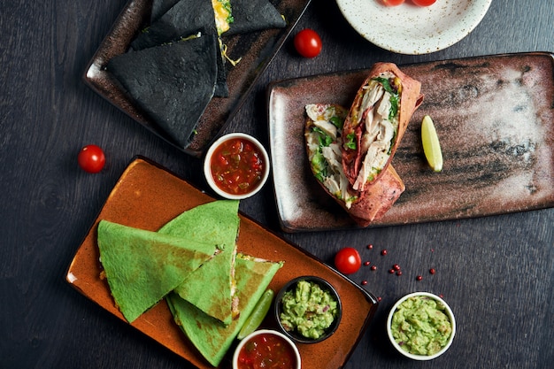 Appetizing Mexican cuisine canned on the table - burritos and quesadillas