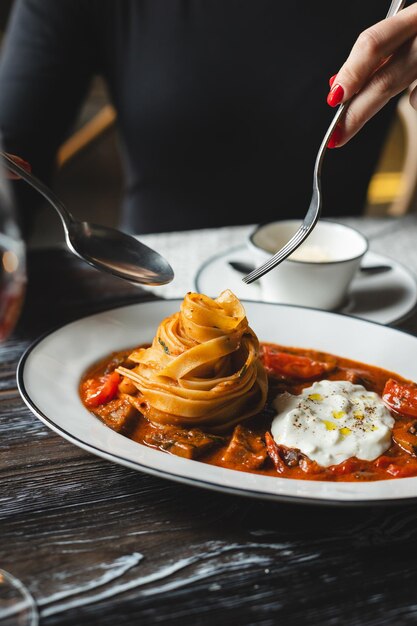 写真 暗い木製のテーブルでトマトソースとチーズを添えた美味しいパスタ レストランの食事サービス