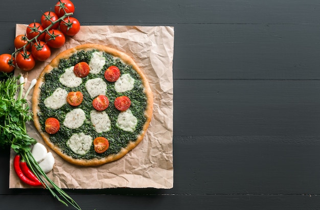 Appetizing pizza with pesto mozzarella and cherry and chili peppers