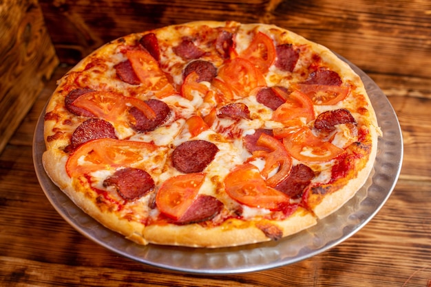 Appetizing pizza with sausage and tomatoes