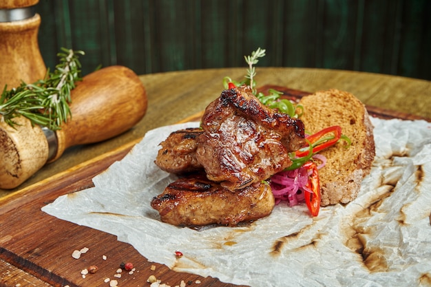 향신료와 나무 표면에 나무 쟁반에 양파 맛 돼지 고기 케밥. Shahlik. 구운 고기의 일부. 클로즈업, 선택적 초점