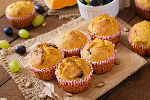 Appetizing and ruddy muffins with pumpkin and grapes