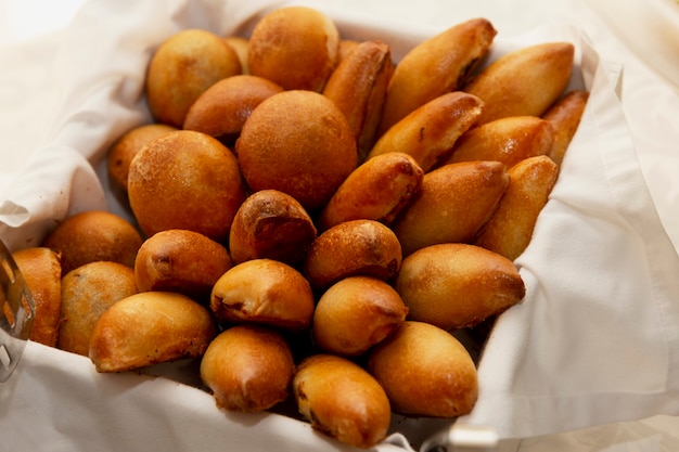 Appetizing Russian pies in a basket with a white napkin on the table.