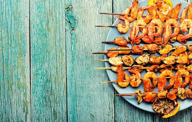 Appetizing shrimps fried on a wooden skewer. Grilled seafood.Copy space