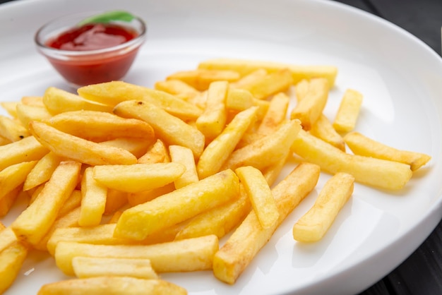 Appetizing side dish French fries with ketchup in a white plate