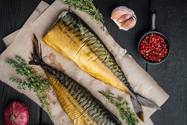 Appetizing smoked fish mackerel, on black wooden table