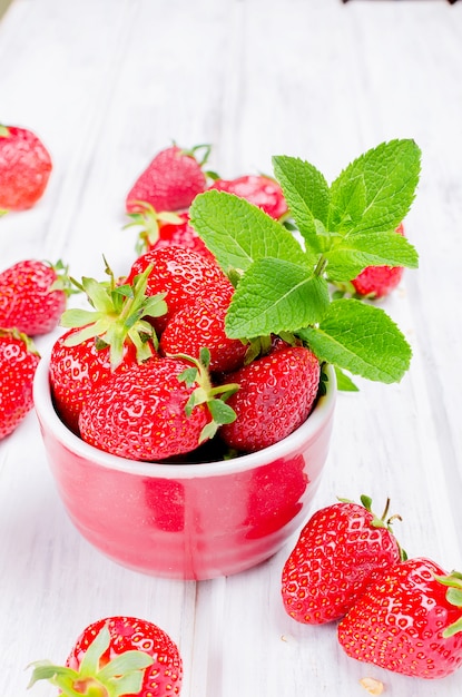 Appetizing strawberry in the bowl on a white table 