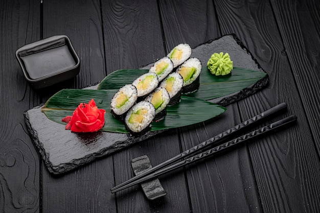 Appetizing sushi maki roll on a black stone plate