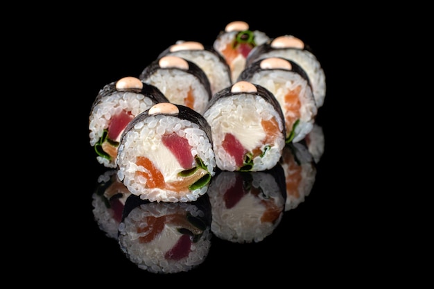 Appetizing sushi roll futomaki on a black background with reflection Sushi menu Japanese kitchen restaurant