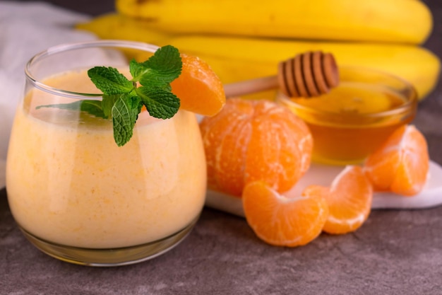 Appetizing tangerine honey smoothie garnished with a mint sprig