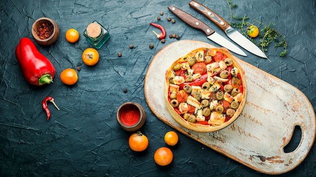 Appetizing tart with cheese, peppers and olives