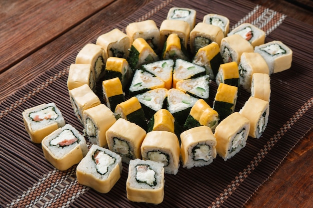 Appetizing tasty great sushi set served on straw mat, top view. Food art, colorful mosaic, restaurant menu photo. Japanese traditional seafood.