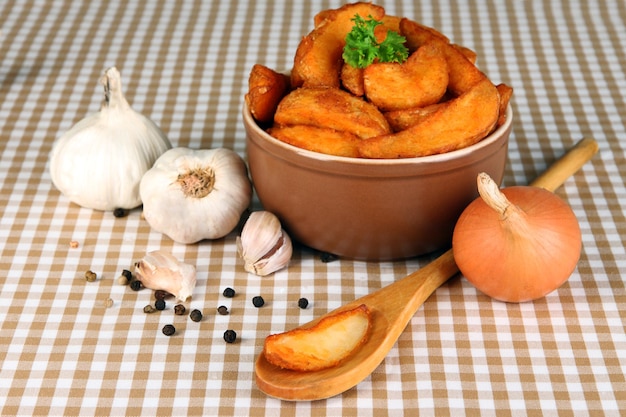 Appetizing village potatoes in bowl on beige tablecloth closeup