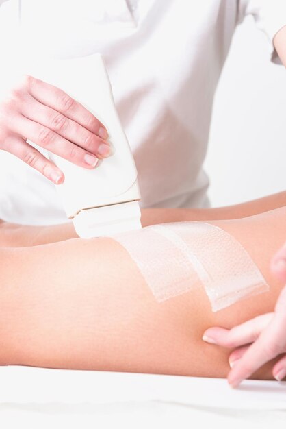 Applaying depilation wax on womans leg