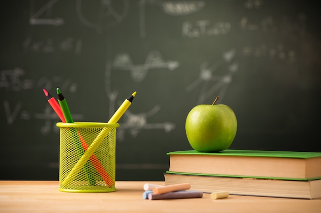 Apple on book on theacher desk. Back to school concept