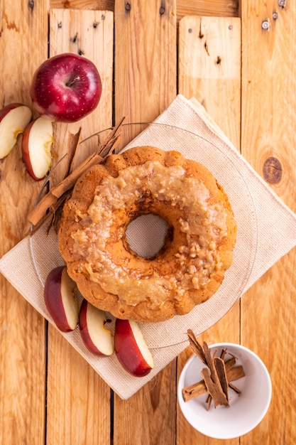 яблочный пирог рядом с кусочками яблок и корицей