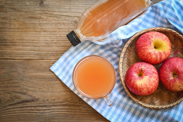 Apple cider vinegar natural remedies and cures for common health condition raw and unfiltered organic apple cider vinegar in glass with apple fruit on the wooden table