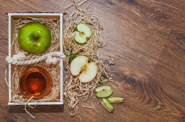 木製の木製の木箱の上に緑りんごとアップルサイダー酢