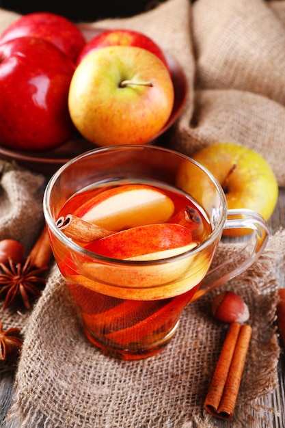 Photo apple cider with cinnamon sticks spices and fresh apples on wooden background